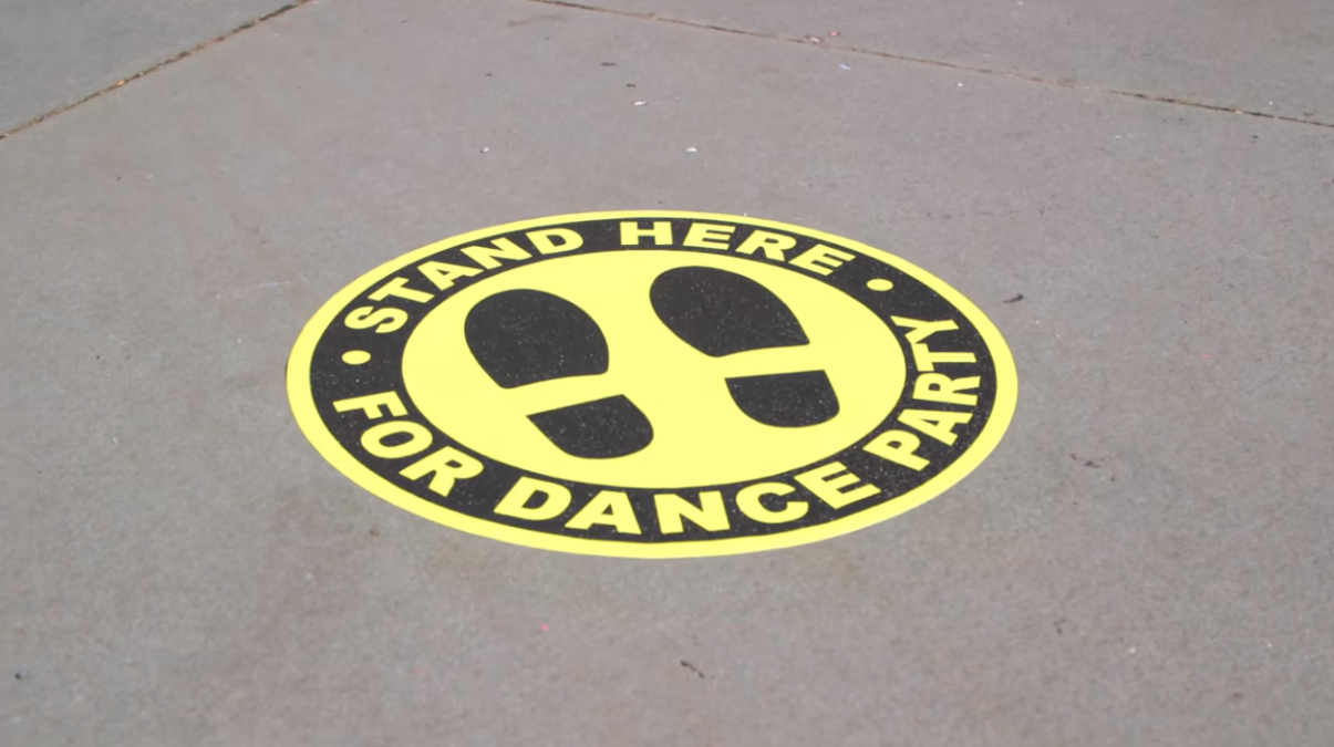 Dance crew surprises passersby standing on "dance party" decal